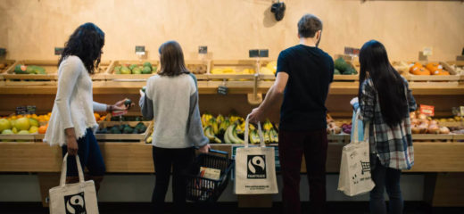 Shoppers in grocery store buying bananas and produce.